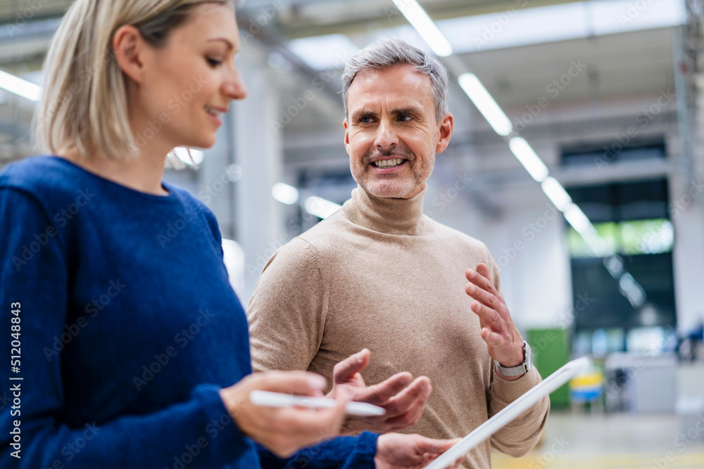 Businessman and businesswoman talking in factory Businessman and businesswoman talking in factory