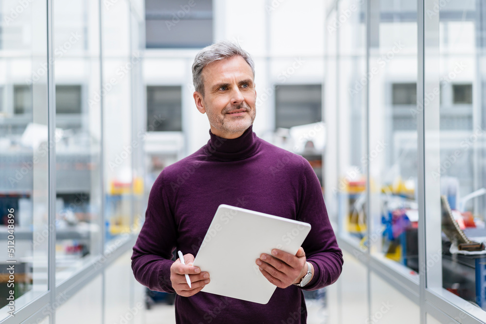 Mature businessman holding digital tablet in factory Mature businessman holding digital tablet in factory