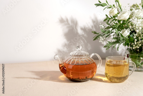 Green tea oolong in glass teapot on table. Hot tea is in the glass cup.