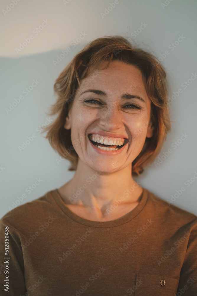 Happy woman standing in front of wall Happy woman standing in front of wall