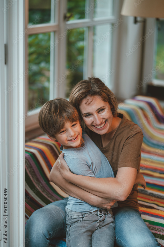 Happy woman with son sitting on sofa at home Happy woman with son sitting on sofa at home