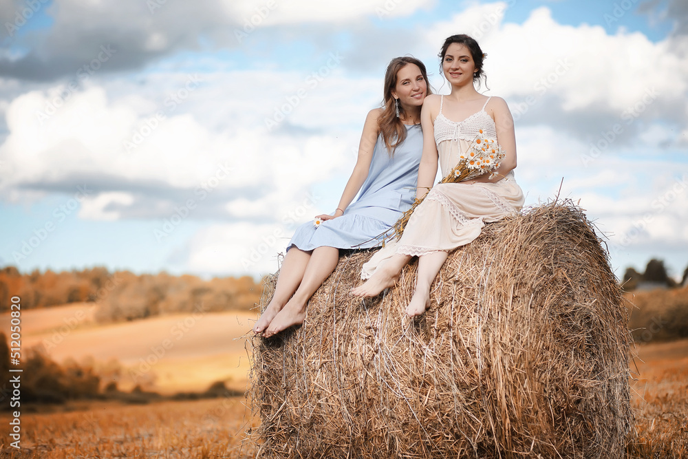 Two girls in dresses in autumn field Two girls in dresses in autumn field