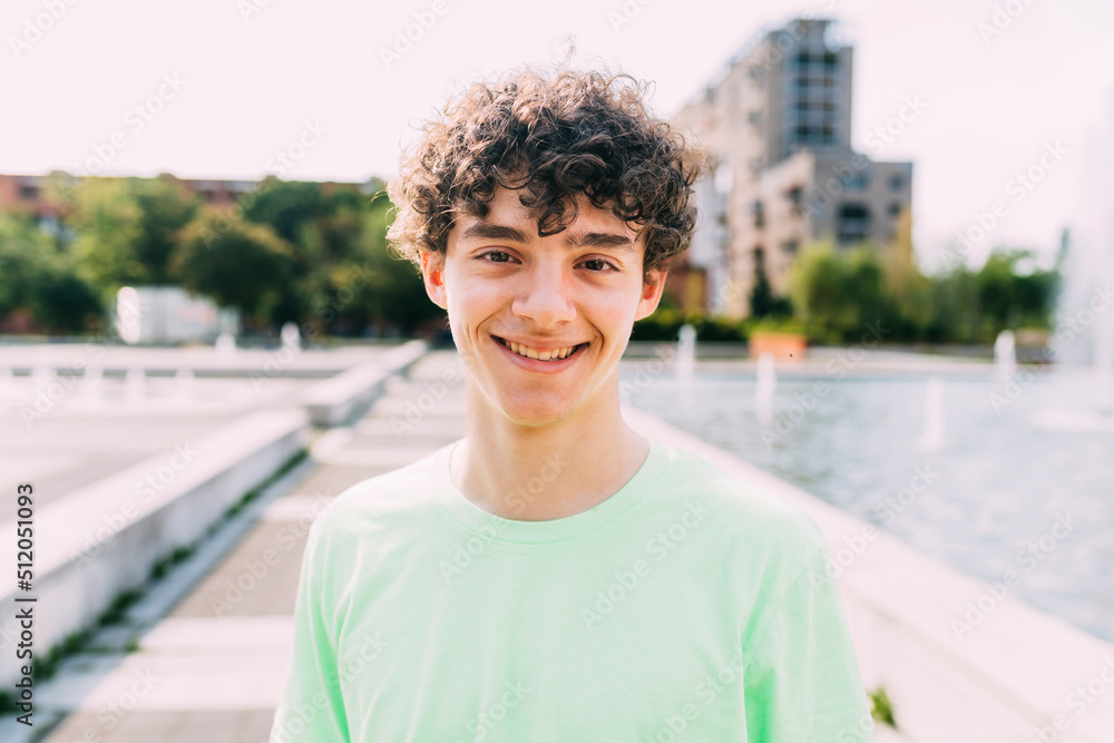Smiling teenage boy with curly hair on sunny day Smiling teenage boy with curly hair on sunny day