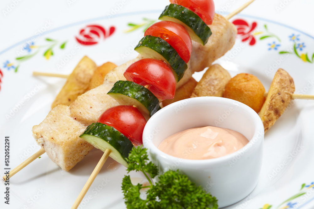 chicken kebab with sauce and vegetables