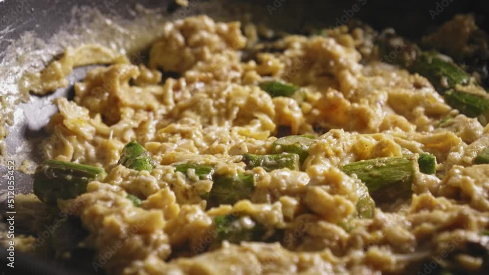 Hot Cooked Scrambled Eggs With Asparagus. Healthy Breakfast Meal. macro shot, pan right Hot Cooked Scrambled Eggs With Asparagus. Healthy Breakfast Meal. macro shot, pan right