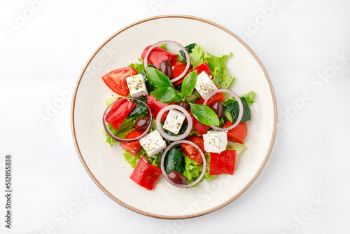 Vegetable salad with fetta cheese and onion on a white background