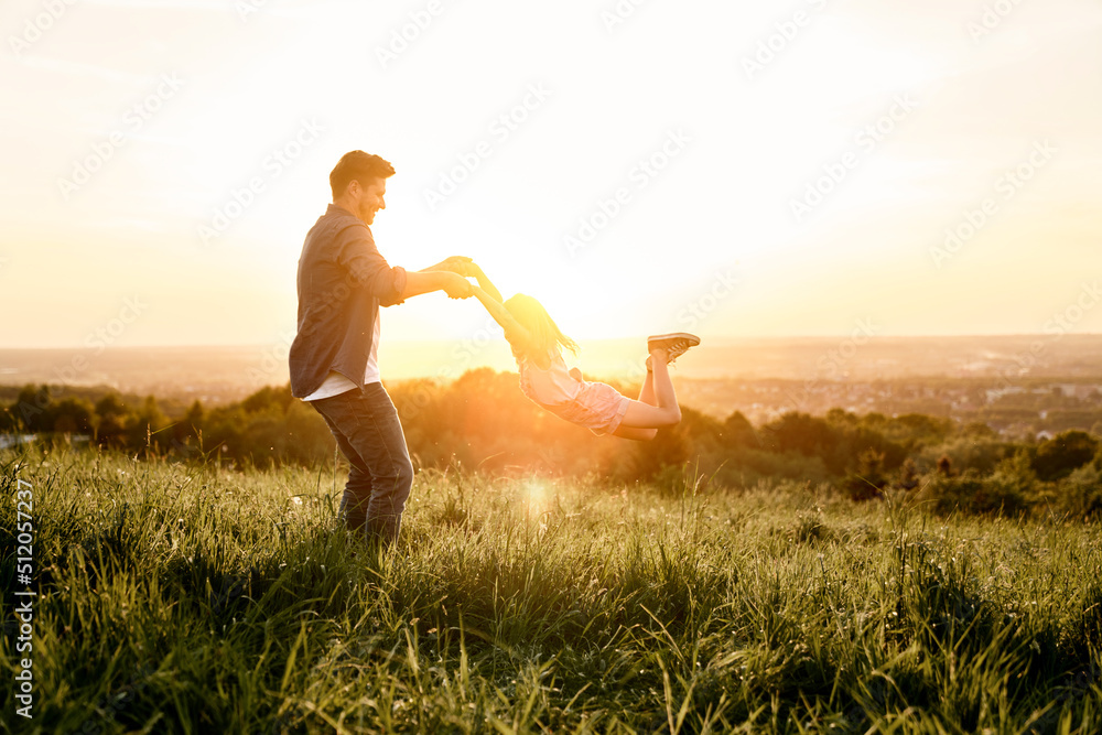 Father with daughter playing together at the meadow