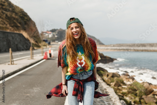 Girl with cap and colored t-shirt smiles