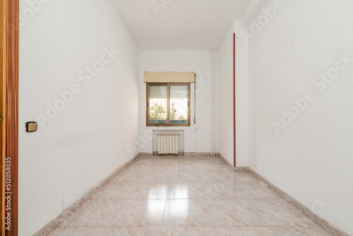 empty room with ceramic tile floors  gold aluminum window and white painted walls