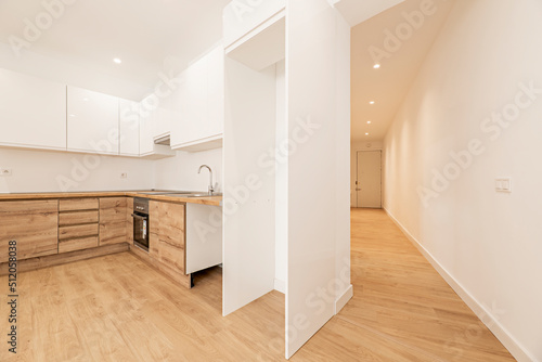 Apartment with chestnut wood furniture  white kitchen in the upper part  oak parquet floors and a long corridor