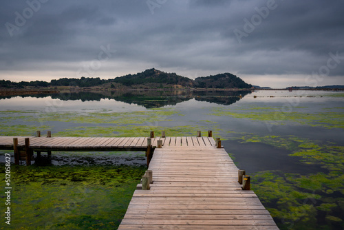 Walkway on a pond full of algae on a natural reserve in the south of France with mountains in the background, Occitanie photo