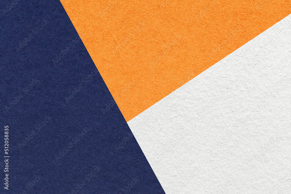 Fototapeta premium Texture of craft navy blue , orange and white shade color paper background, macro. Structure of abstract cardboard