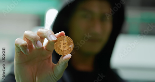 young asian hacker showing bitcoin