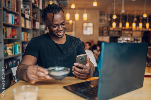 African american man using laptop while drinking coffee in a cafe