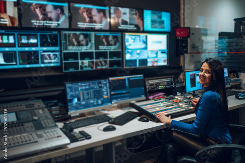 Middle aged woman using equipment in control room on a tv station