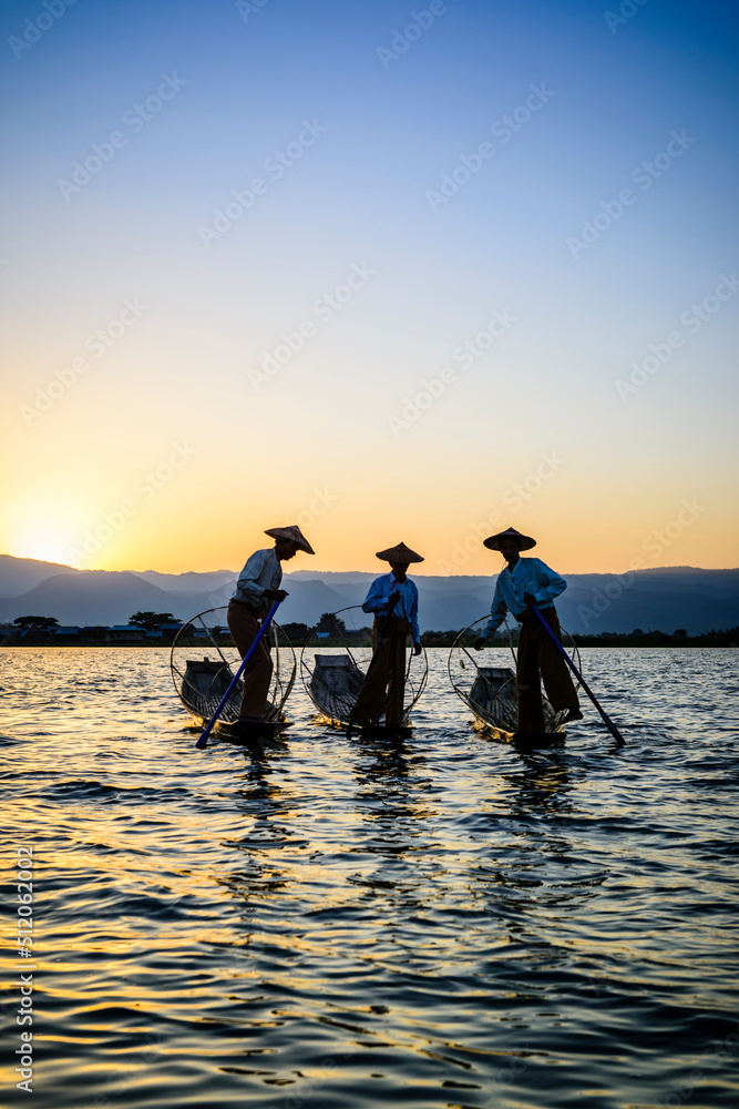 Three fishermen on Lake Inles, standing in their traditional boats. Three fishermen on Lake Inles, standing in their traditional boats.