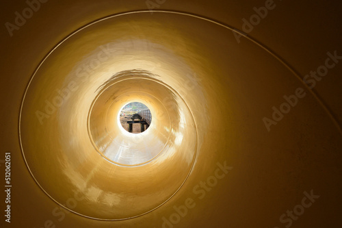 View through a narrow object with a spiral pattern to a street scene. photo