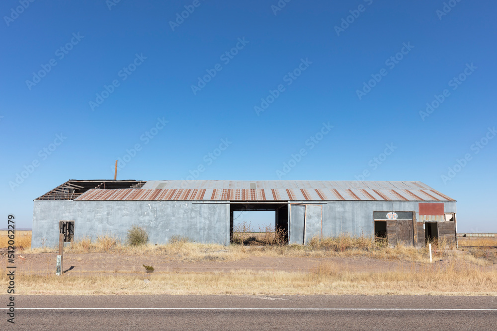 Abandoned rusting metal farm building with large open doors. Abandoned rusting metal farm building with large open doors.