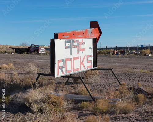 Rusty roadside sign advertising a reststop, deserted trucks and rubbish. photo