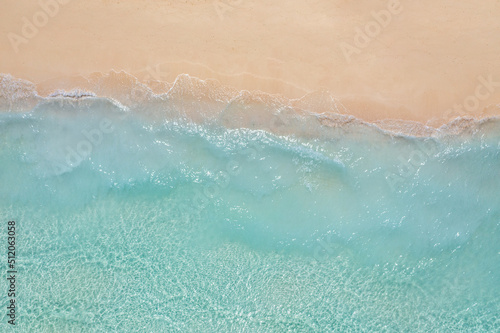 Relaxing aerial beach, summer vacation holiday template banner. Waves surf with amazing blue ocean lagoon, sea shore, coastline. Beautiful aerial drone top view. Tranquil bright beach, seaside nature