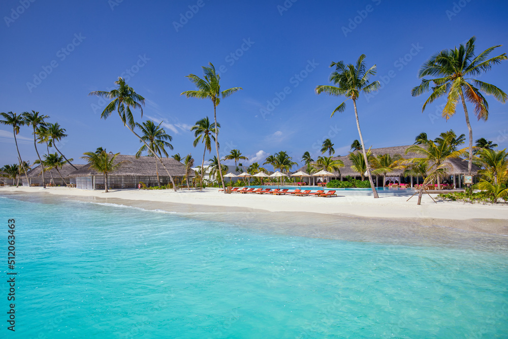 Outdoor tourism landscape. Luxurious beach resort with swimming pool and beach chairs or loungers under umbrellas with palm trees, sunny sky. Summer travel and vacation background concept