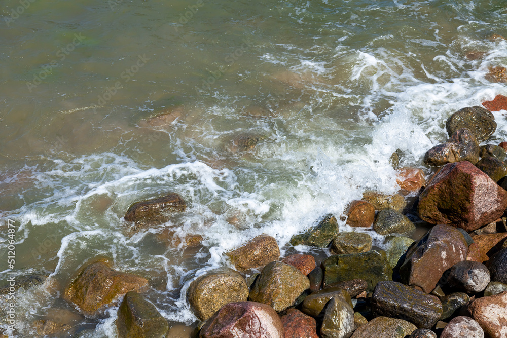 Sea wave and wet stones, background
