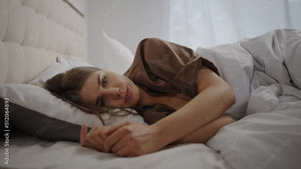 Woman tries to handle sadness lying on bed after waking up Woman tries to handle sadness lying on bed after waking up