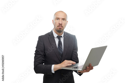 Bald man in suit looking very attentively at a laptop in his hands isolated on white background.