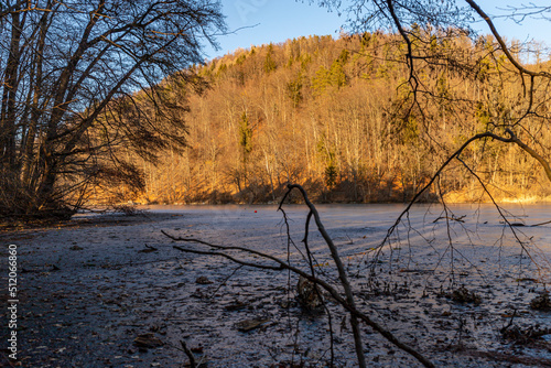 Abendstimmung am Thalersee in Graz mit umgestürzten Baum auf dem See photo