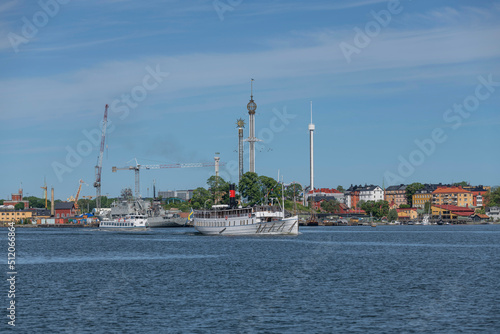 Commuter boats leaving Stockholm for the archipelago, steam ship Vaxholm lll and a modern boat a sunny summer day in Stockholm