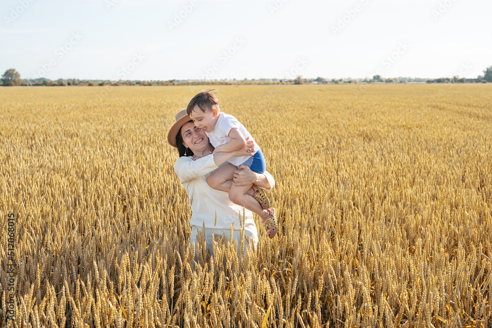 Happy family of mother and infant child walking on wheat field Happy family of mother and infant child walking on wheat field