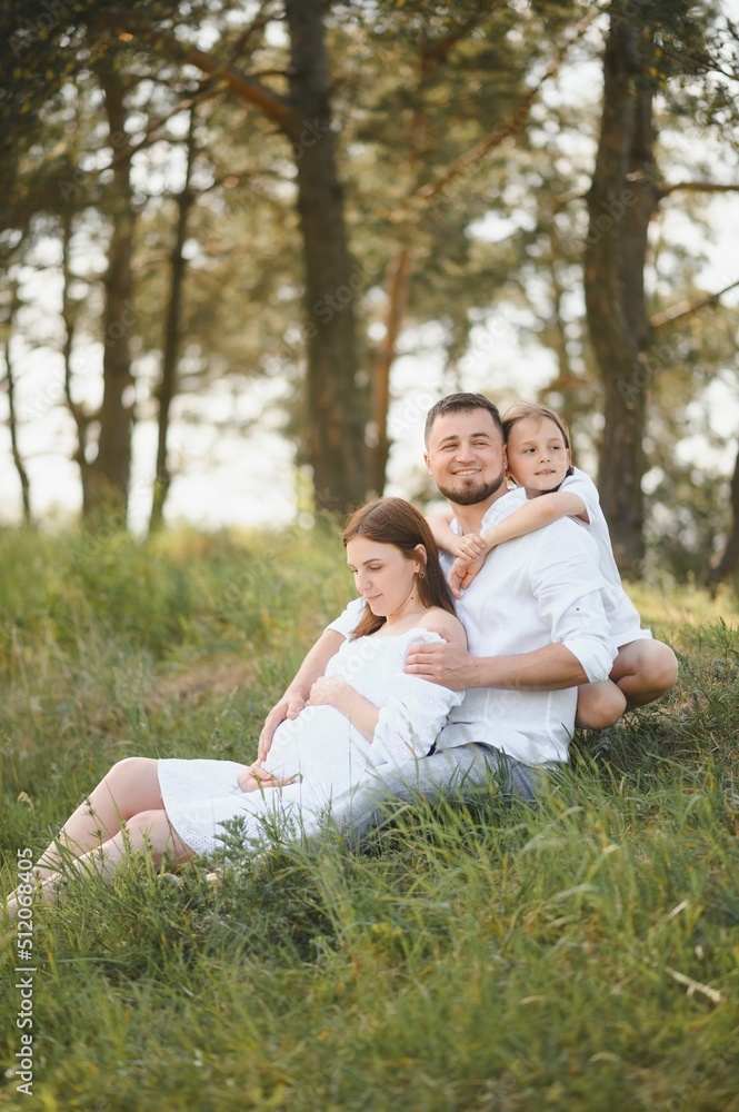 Happy pregnant couple with daughter in summer nature. Happy pregnant couple with daughter in summer nature.