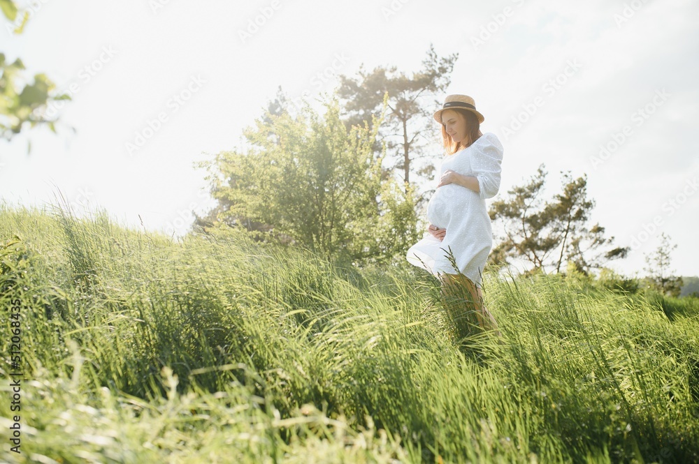 Beautiful pregnant woman relaxing outside in the park Beautiful pregnant woman relaxing outside in the park