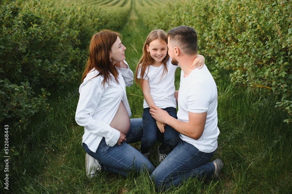 Happy pregnant couple with daughter in summer nature. Happy pregnant couple with daughter in summer nature.