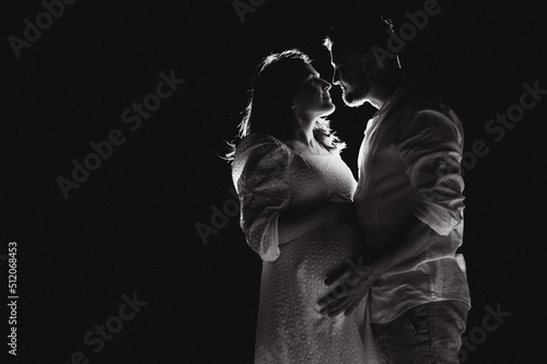 Happy Pregnant Couple. Mother and Father Love expecting Baby during Pregnancy. Family waiting Child Birth over Black night Background