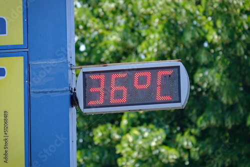 Street thermometer marking 36 degrees celsius in summer photo