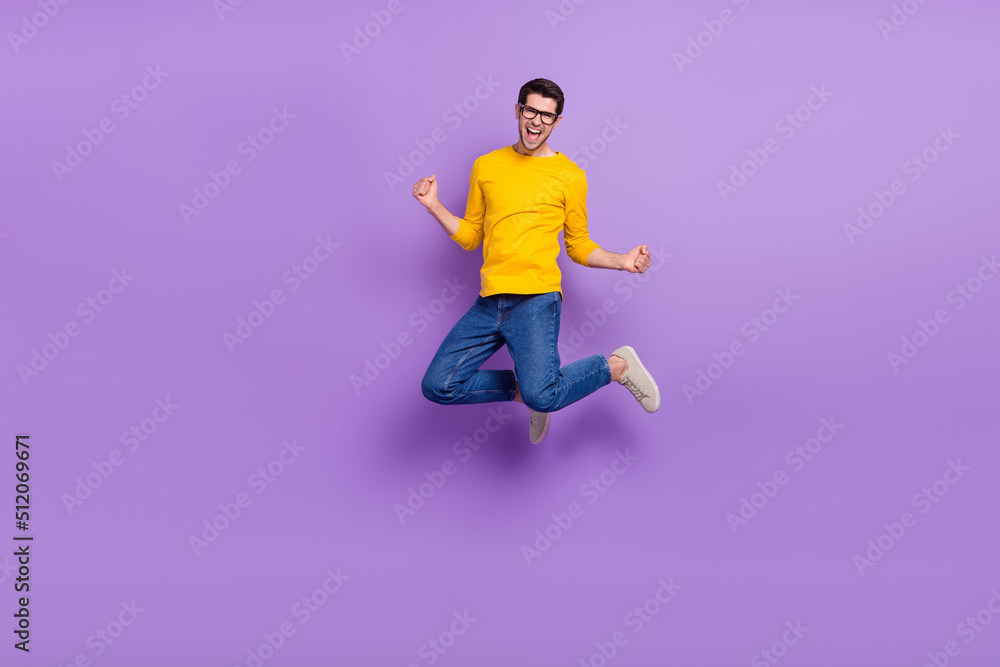 Full body image of overjoyed funny man jumping in victory win money prize lottery isolated on violet color background