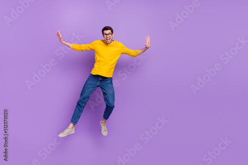 Full body photo of smiling handsome youth man jump up enjoy summer vacation isolated on violet color background