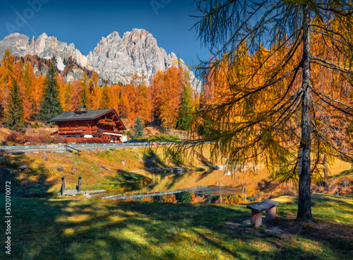 Astonishing autumn view of Scin lake with wooden shalet. Exciting morning scene of outskirts of Cortina d'Ampezzo town, Province of Belluno, Italy, Europe. Majestic landscape of Dolomite Alps.