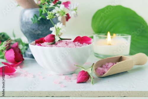 Fresh pink and purple roses, water and sea salt with flower petals, on a light background, natural cosmetics, body care, love emotion