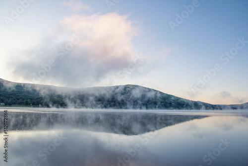 Morning fog over. a mountain lake, landscape vacation theme, summer.