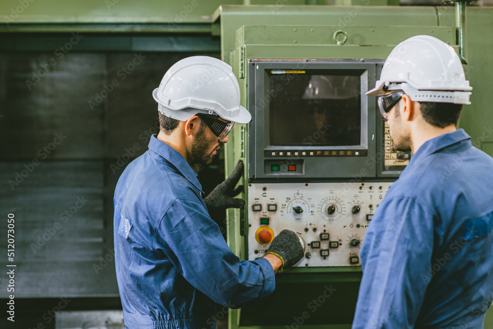 Experienced Engineer Staff Worker working together in metal factory operate setup CNC machine. Experienced Engineer Staff Worker working together in metal factory operate setup CNC machine.