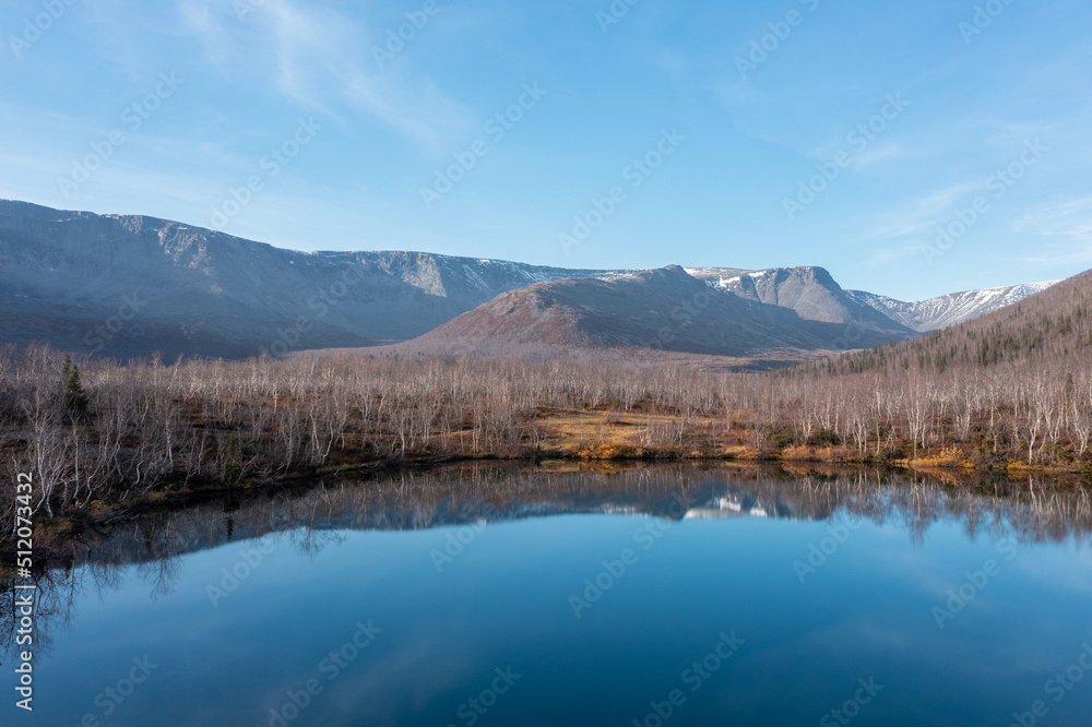 Blue mountain lake on the background snow-capped mountain picks in polar autumn. Landscapes of Northern Nature. Nature regions of Russia. Russian north. Blue mountain lake on the background snow-capped mountain picks in polar autumn. Landscapes of Northern Nature. Nature regions of Russia. Russian north.