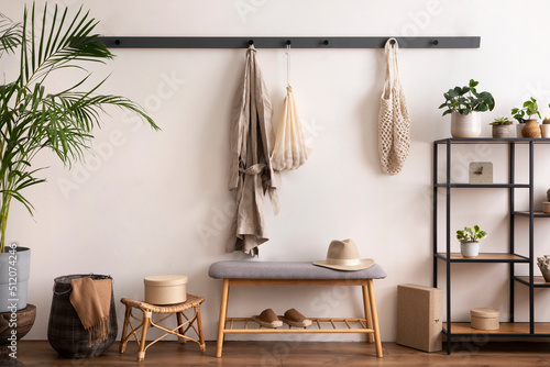 The stylish composition of cosy entryway with grey bench, black consola, hanger and plant. Beige wall. Home decor. Template. © FollowTheFlow