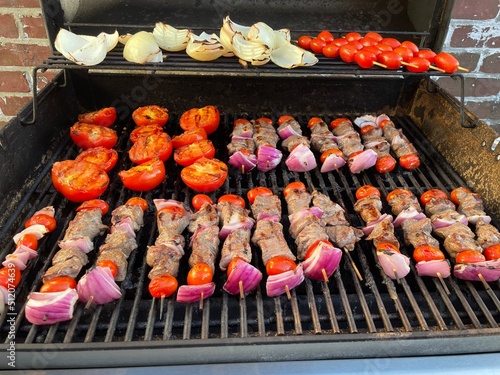 shish kebabs with onions and tomatoes on the barbecue grill