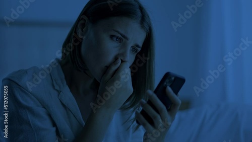 Woman suffers from insomnia trying to distract on smartphone photo