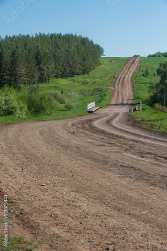 dirt road going up hill and bridge on a spring morning