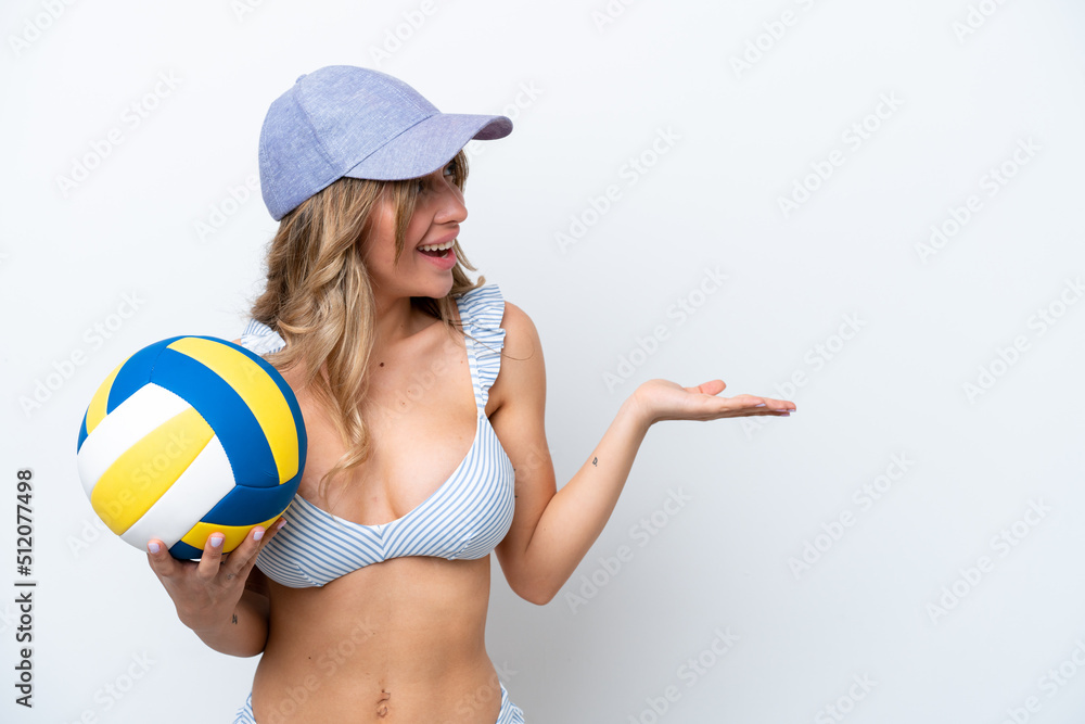 Young woman playing volleyball wearing a swimsuit isolated on white background with surprise facial expression