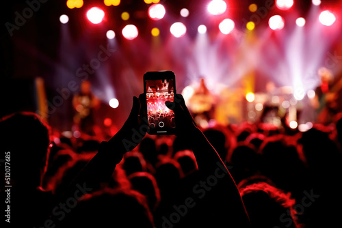 Bild auf Leinwand Streaming a music concert to social media via smartphone.