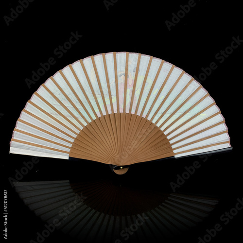 antique fan on a black isolated background with a painting. fan with a close-up painting. retro fan depicting Spanish dancers